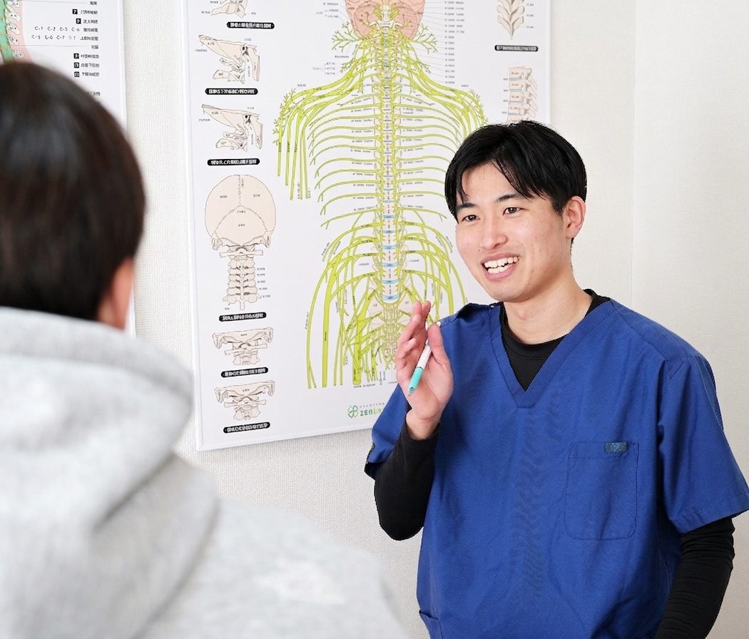 神経系の図を使って体の状態を説明する施術師