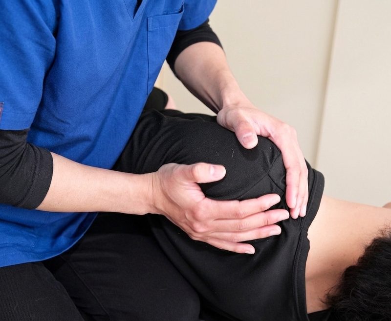 肩を両手で確認する施術の手元